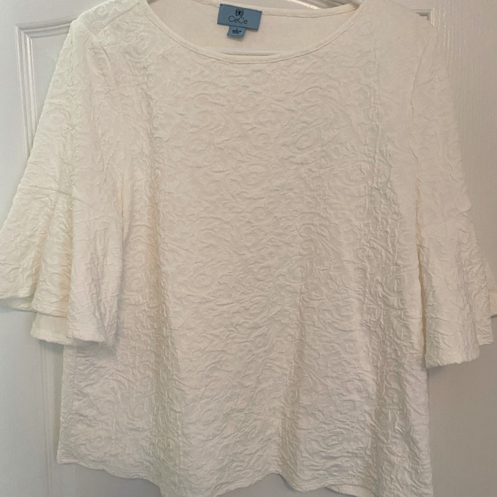 Short sleeve top,flutter sleeves,raised scroll design. 96% Polyester 4% Spandex